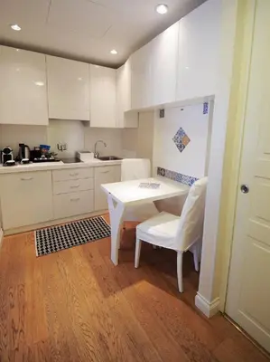 a kitchen with a white table and white chairs at Royal Suite Trinità Dei Monti in Rome