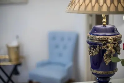 a blue vase sitting on a table with a lamp at Royal Suite Trinità Dei Monti in Rome