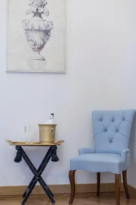a blue chair sitting next to a table with a vase at Royal Suite Trinità Dei Monti in Rome