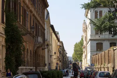 a street with buildings and cars on a city street at TrastevereHome - Sales Rome in Rome