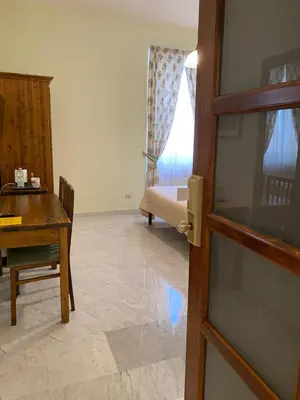 a living room with a table and a desk and a door at Guest House Laocoonte in Rome