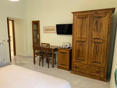 a bedroom with a desk and a large wooden cabinet at Guest House Laocoonte in Rome