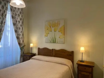 a bedroom with a bed and two lamps and a window at Guest House Laocoonte in Rome