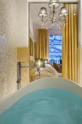 a bathroom with a tub in front of a bedroom at Lifestyle Suites Rome in Rome