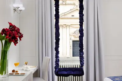 a blue chair in a room with a table and a mirror at Lifestyle Suites Rome in Rome