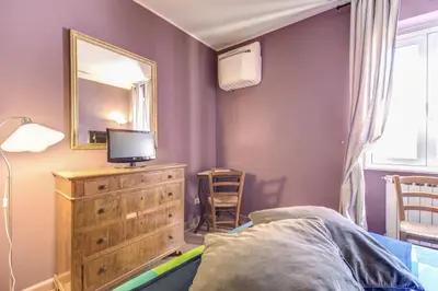 a room with a table and chairs and bookshelves at Frangipane Apartment in Rome
