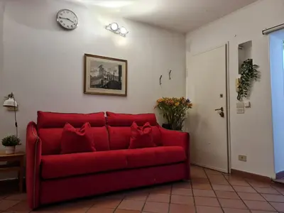 a bedroom with a bed and a red chair at Frangipane Apartment in Rome