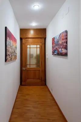 a hallway with a door and two pictures on the wall at Vatican Art Place in Rome