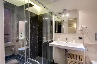 a bathroom with a sink and a glass shower at Navona Living Rome in Rome