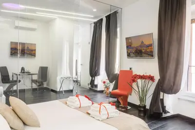 a bedroom with two beds and a red chair at Navona Living Rome in Rome