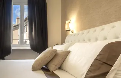 a bedroom with a white bed with a window at Navona Living Rome in Rome