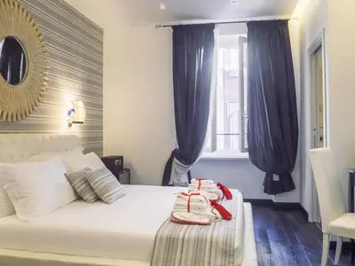 a bedroom with a white bed with blue curtains at Navona Living Rome in Rome