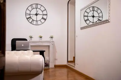 a white room with a desk and a clock on the wall at Ripetta 35 in Rome