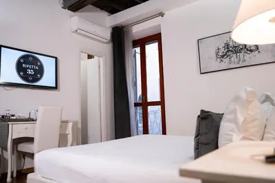 a bedroom with a bed and a desk and a window at Ripetta 35 in Rome