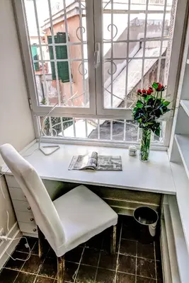 a window seat with a table and a vase with flowers at Good Life Monti in Rome