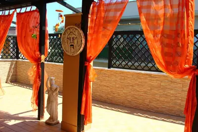 a building with orange curtains and a clock on a pole at Tempio del Sole in Rome