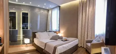 a bedroom with a bed and a chair and a window at Sun Suite Luxury Pantheon in Rome