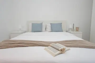 a white bed with an open book at Il Villino di Adelchi by DomusDimore in Rome