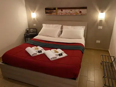 a bedroom with a bed with two towels on it at Kings Of Rome Apartments in Rome