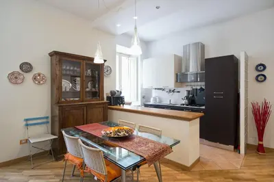 a kitchen with a table and a black refrigerator at Casa Elena - ItalyHolidayHouse in Rome