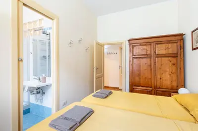a bedroom with a yellow bed and a sink at Casa Elena - ItalyHolidayHouse in Rome