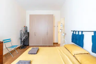 a bedroom with a large yellow bed and a closet at Casa Elena - ItalyHolidayHouse in Rome