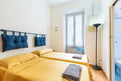 a bedroom with two beds with blue pillows at Casa Elena - ItalyHolidayHouse in Rome