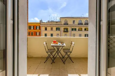 a table on a balcony with a view of a building at Un Attimo A Roma B&B in Rome