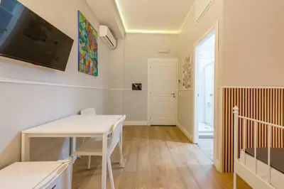 a dining room with a table and a tv at Un Attimo A Roma B&B in Rome