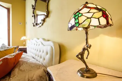 a lamp sitting on a table next to a bed at Impero Vaticano Navona Apartment in Rome