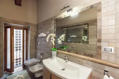 a bathroom with a sink and a toilet and a mirror at Impero Vaticano Navona Apartment in Rome