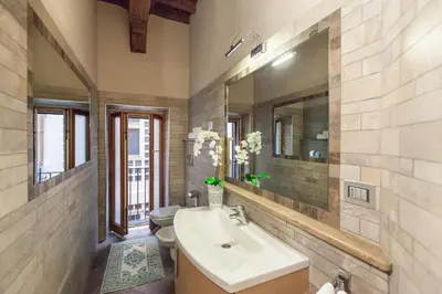 a bathroom with a sink and a toilet and a mirror at Impero Vaticano Navona Apartment in Rome
