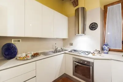 a kitchen with white cabinets and a sink at Impero Vaticano Navona Apartment in Rome