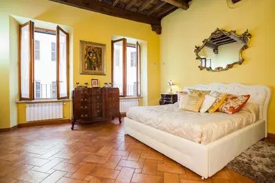 a bedroom with a white bed and yellow walls at Impero Vaticano Navona Apartment in Rome