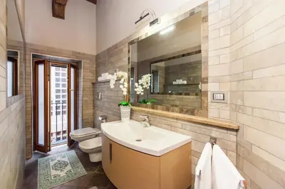 a bathroom with a sink and a toilet and a mirror at Impero Vaticano Navona Apartment in Rome