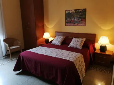 a bedroom with a bed with red sheets and two lamps at B&B La Bella Giuliana in Rome