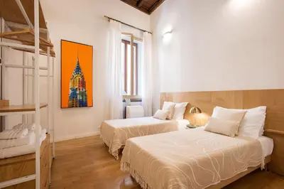 a bedroom with two beds and a painting on the wall at Avila Palace Piazza Navona in Rome