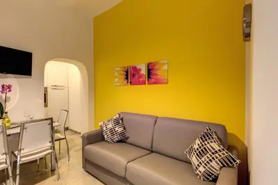 a living room with a couch and a yellow wall at Domus Vita Romana in Rome