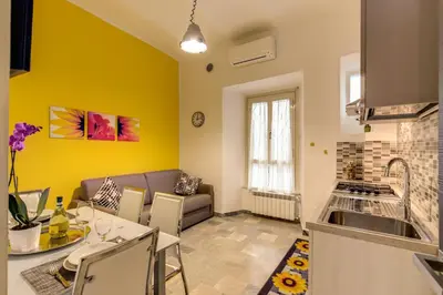 a kitchen and a living room with yellow walls at Domus Vita Romana in Rome