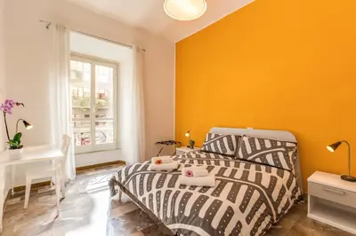 a bedroom with a bed and a yellow wall at Domus Vita Romana in Rome