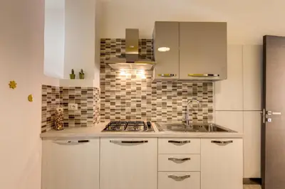 a kitchen with white cabinets and a sink at Domus Vita Romana in Rome