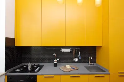 a yellow kitchen with a stove and a sink at La Dolce Vista Trastevere in Rome