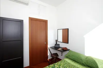 a bedroom with a bed and a desk and a mirror at La Dolce Vista Trastevere in Rome