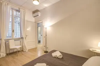 a white bedroom with a bed and a window at M&L Apartment - Caracalla Holiday in Rome