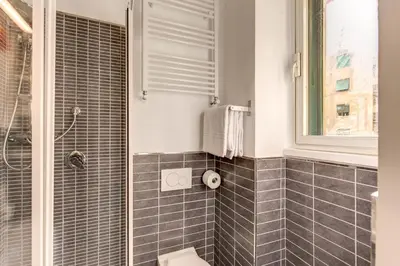 a bathroom with a shower and a toilet and a window at M&L Apartment - Caracalla Holiday in Rome