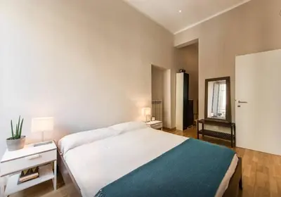 a bedroom with a bed and a table and a mirror at Casa Oliva in Rome