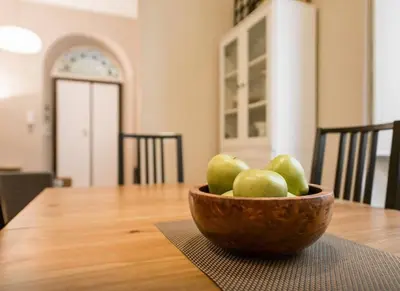 a bowl of green apples sitting on a wooden table at Casa Oliva in Rome
