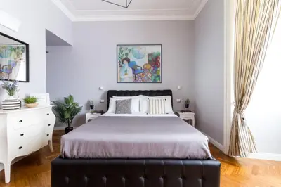 a bedroom with a black bed and a white dresser at Athena Guest House in Rome