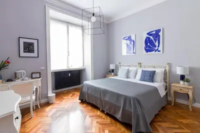 a white bedroom with a bed and a desk at Athena Guest House in Rome