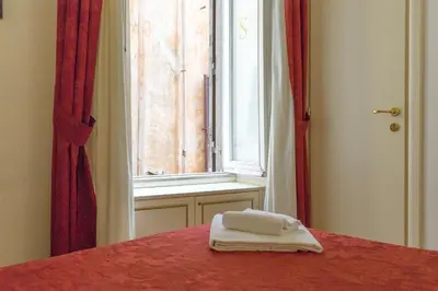 a pair of towels sitting on a bed in front of a window at Best Suites Pantheon in Rome